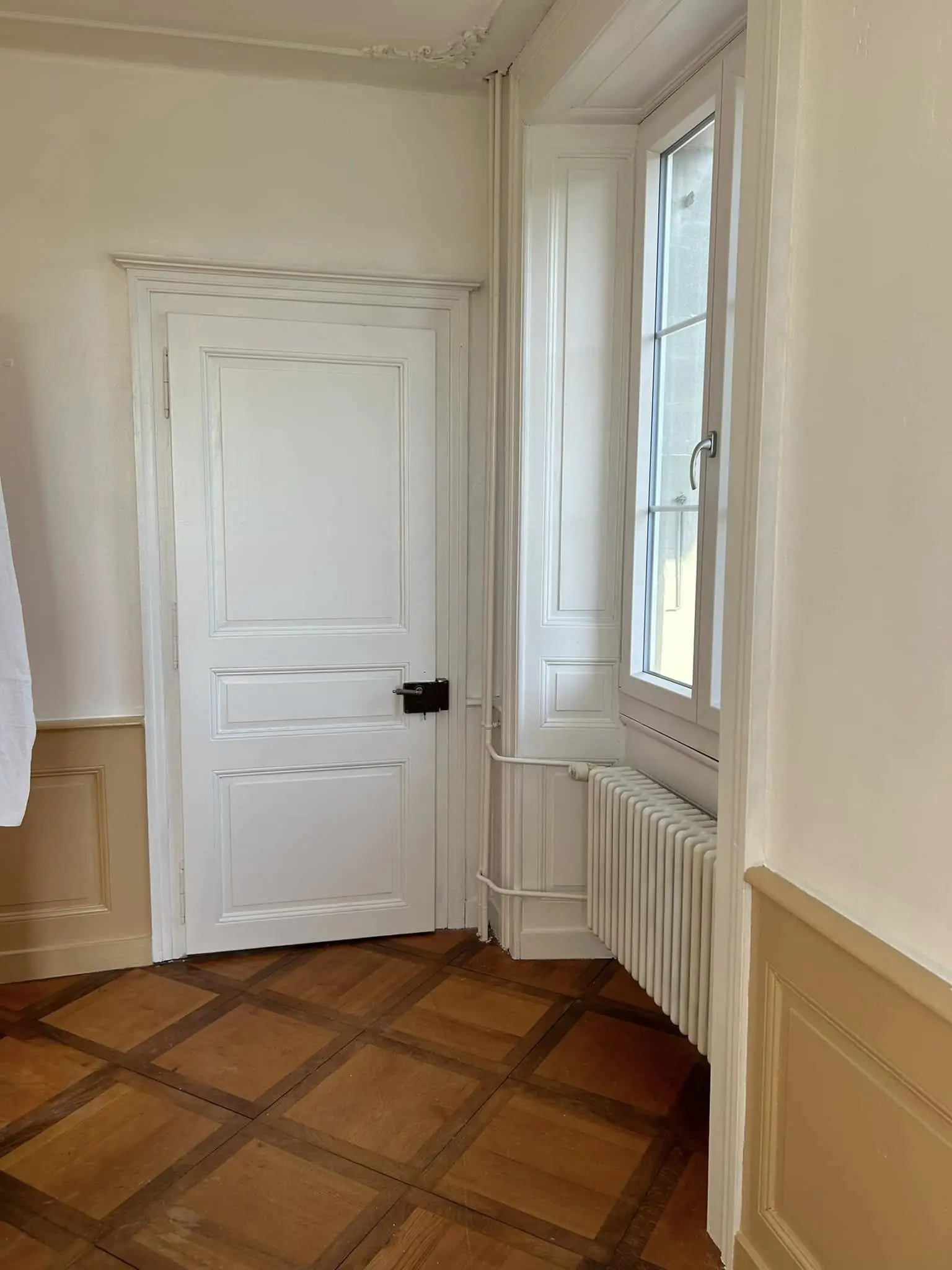 Porte et son encadrement laqués en blanc, soubassement repeint en beige de chaque côté