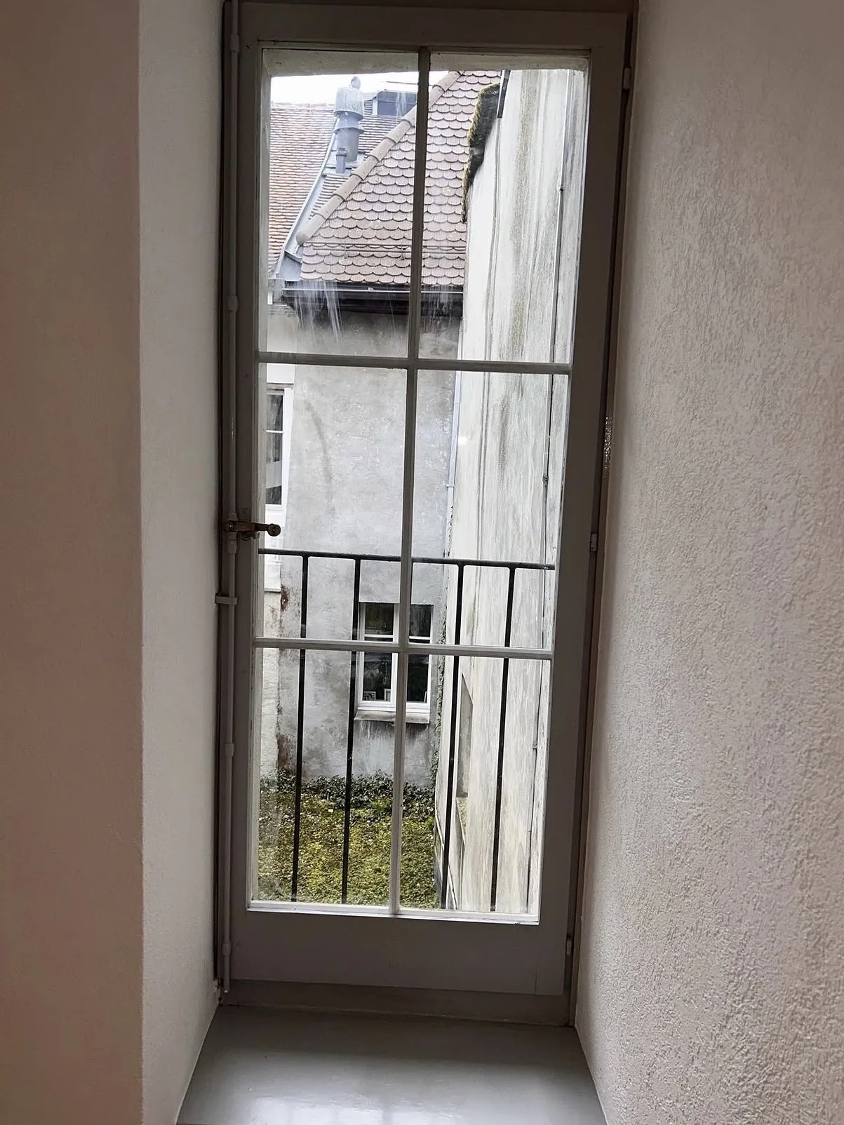 Porte-fenêtre et cadre repeints en gris clair, murs crépis blancs, à Estavayer-le-Lac