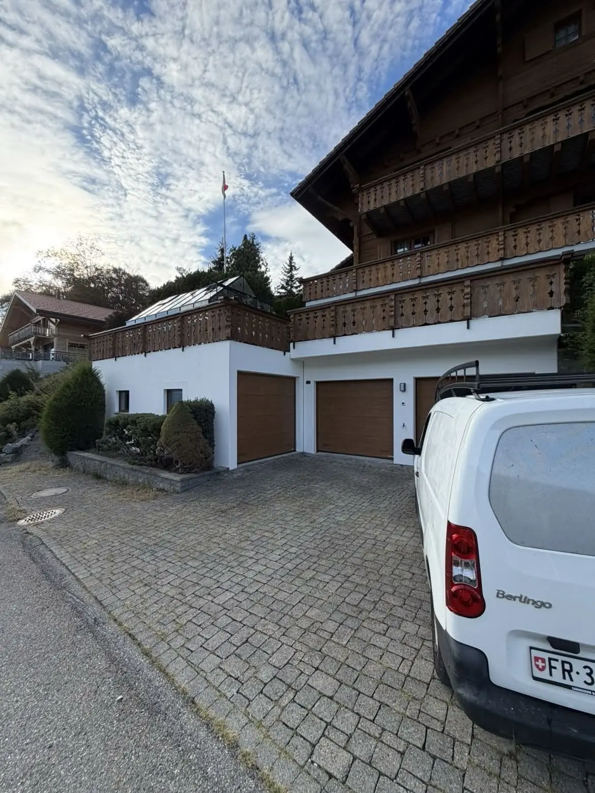 Façade du chalet depuis la rue, boiseries des balcons lasurées en deux couches