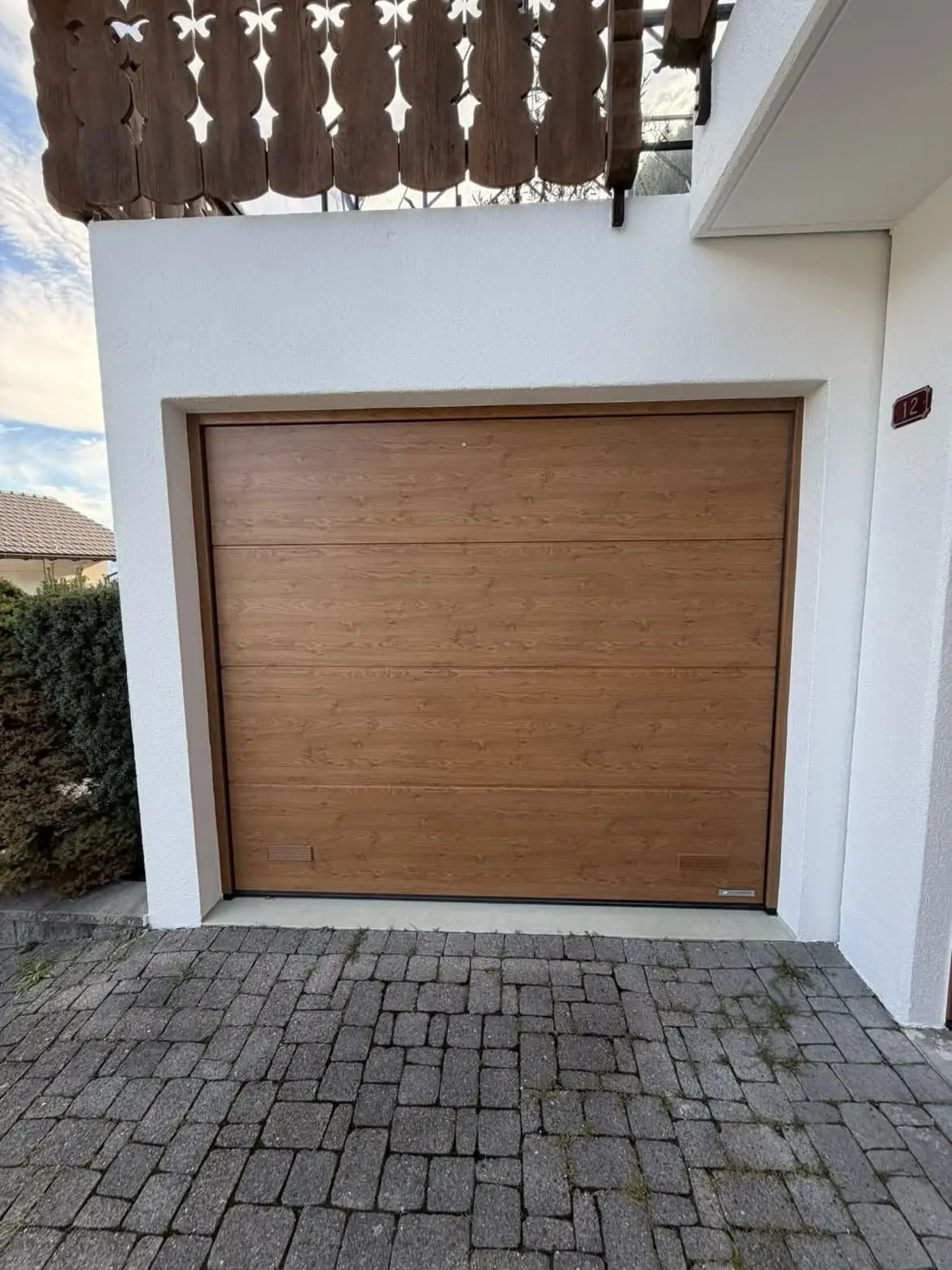 Porte de garage remise en teinte, crépi de la façade repeint en blanc autour de l'encadrement
