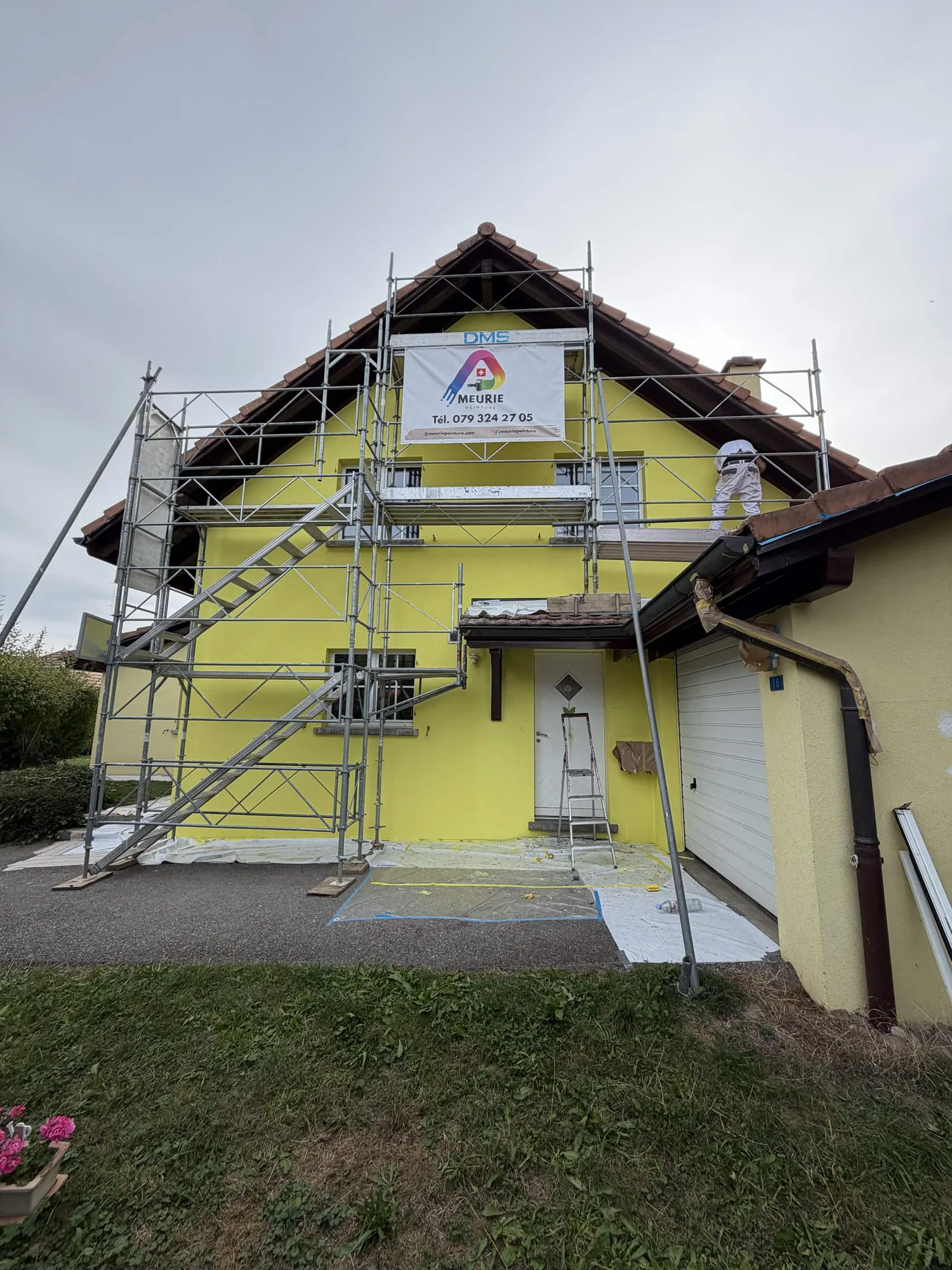 Échafaudage sur le pignon pendant la mise en peinture de la façade, à Billens
