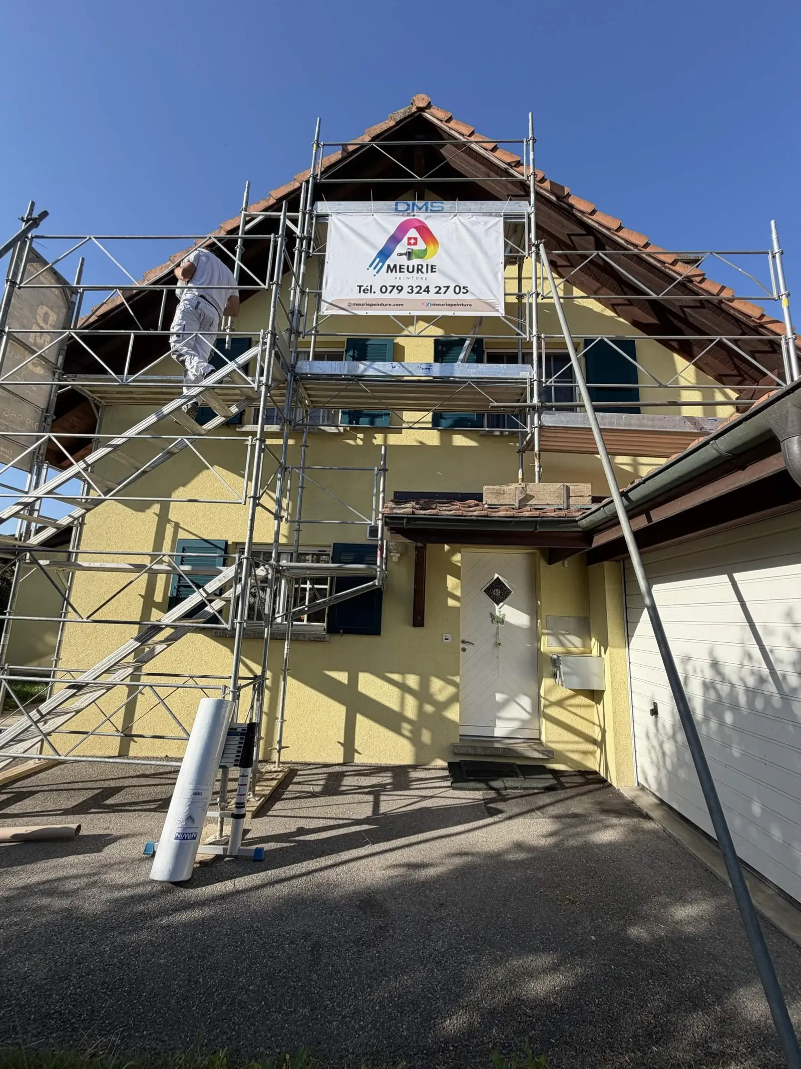 Échafaudage monté jusqu'au faîte pour repeindre la façade sur rue et ses avant-toits