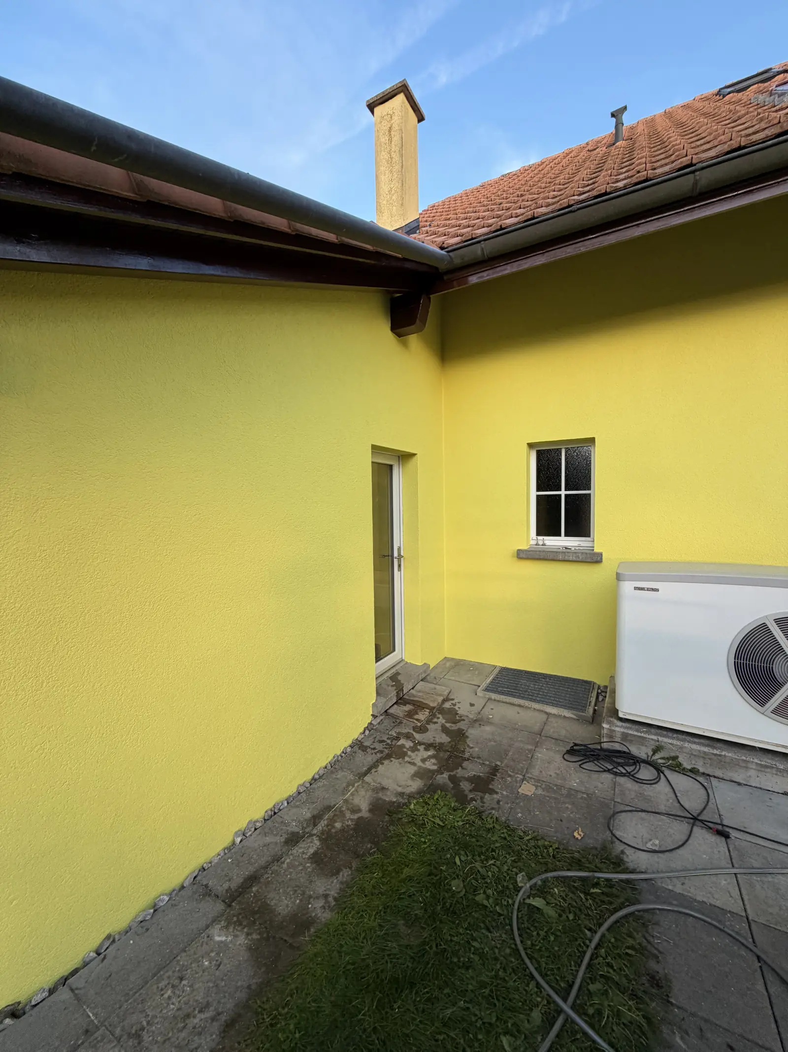 Angle arrière de la maison, crépi lavé puis repeint en deux couches jusqu'à la porte de service