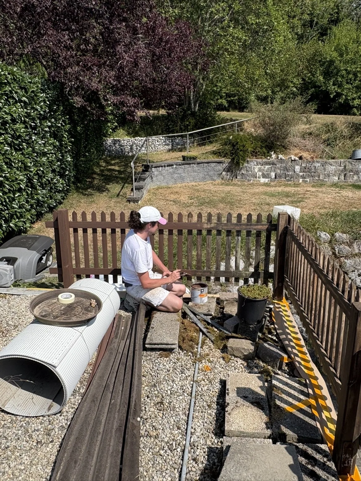 Peinture d'une barrière en bois au pinceau, à Oron-le-Châtel