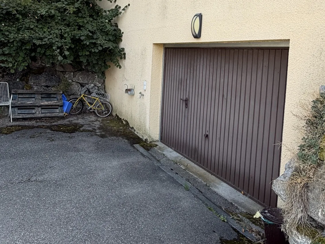 Avant : Façade repeinte en deux couleurs, jaune pâle et terre cuite. Porte de garage poncée, traitée et repeinte en brun.