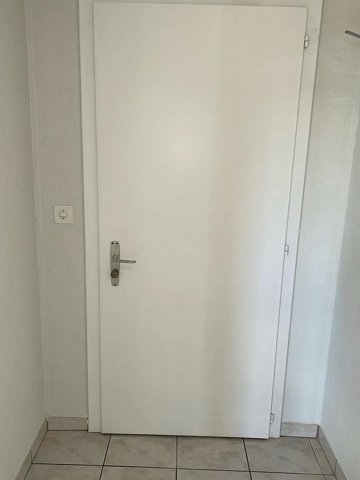 Porte intérieure et cadre repeints en blanc, à Estavayer-le-Lac