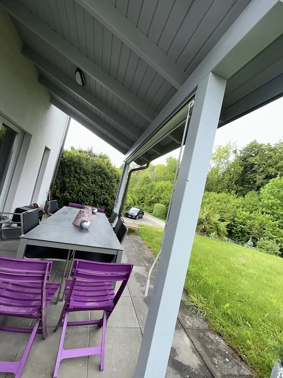 Sous-face lambrissée d'une terrasse couverte peinte en gris clair, à Châbles